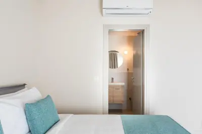 a bedroom with a white bed and a sink at Link by Zoia Living in Athens