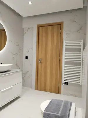 a bathroom with a sink and a wooden door at Amazing Sea View Next To The Beach 2bd Apt in Athens