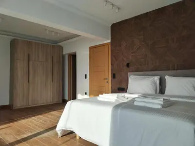 a bedroom with a large white bed with wooden walls at Amazing Sea View Next To The Beach 2bd Apt in Athens