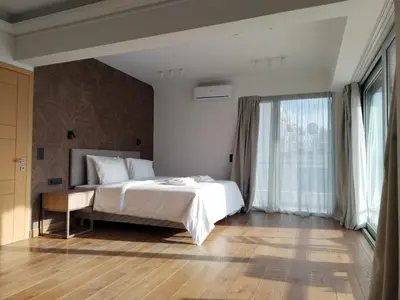 a bedroom with a white bed and a large window at Amazing Sea View Next To The Beach 2bd Apt in Athens