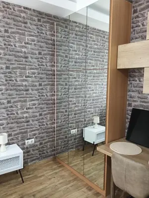 a glass shower in a room with a brick wall at Βιργινία κοντα σε μετρο πανορμου και σε νοσοκομεια in Athens