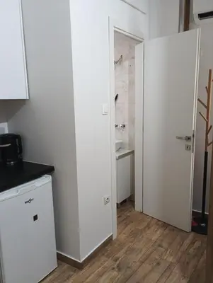 a white kitchen with a sink and a bathroom at Βιργινία κοντα σε μετρο πανορμου και σε νοσοκομεια in Athens