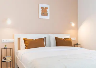 a bedroom with a white bed with orange pillows at Livinn Acropolis View LV in Athens