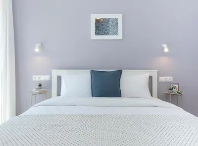 a white bed with white sheets and blue pillows at Livinn Acropolis View LV in Athens