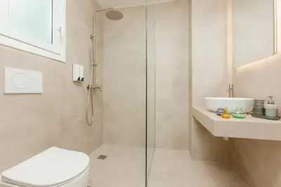 a bathroom with a shower and a toilet and a sink at Livinn Acropolis View LV in Athens