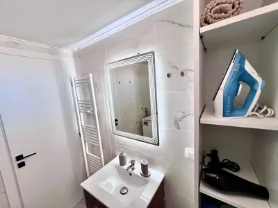 a bathroom with a sink and a mirror at Krystalli 3BR apartment in Voula by ΜΡS in Athens