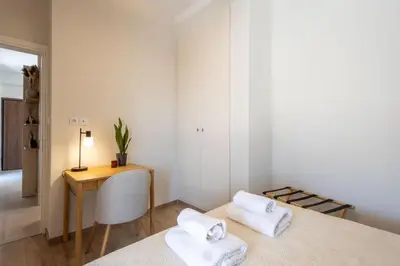 a bedroom with a bed and a table and a desk at Whispering Veranda in Athens