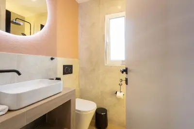 a bathroom with a sink and a toilet and a mirror at Whispering Veranda in Athens