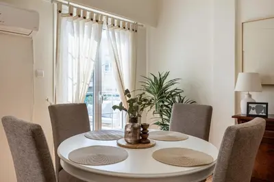 a dining room with a white table and chairs at Eleni's Terrace in Ampelokipi in Athens