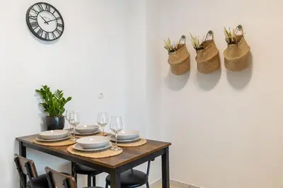 a table with plates and glasses and a clock on the wall at Eleni's Terrace in Ampelokipi in Athens