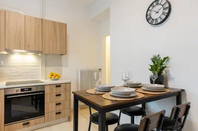 a kitchen with a table and a clock on the wall at Eleni's Terrace in Ampelokipi in Athens