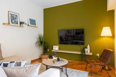 a living room with a tv on a green wall at Eleni's Terrace in Ampelokipi in Athens