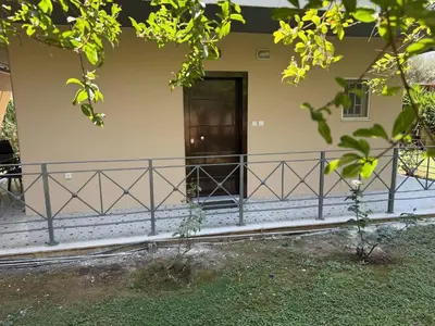 a front porch of a house with a black railing at SeaWave Porto Rafti in Porto Rafti