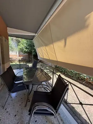 a patio with chairs and a table and a tent at SeaWave Porto Rafti in Porto Rafti