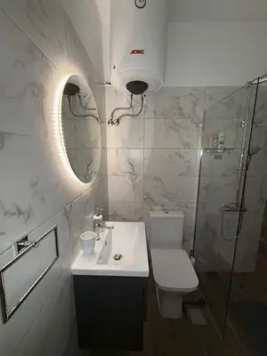 a bathroom with a toilet and a sink and a mirror at SeaWave Porto Rafti in Porto Rafti