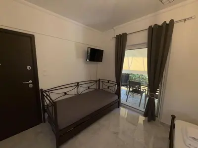a bedroom with a bed and a window with a balcony at SeaWave Porto Rafti in Porto Rafti