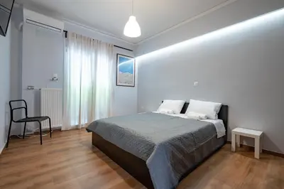 a bedroom with a bed and a chair in it at Minimal Frame by ΜΡS in Athens