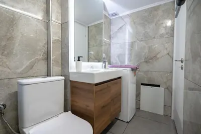 a bathroom with a white toilet and a sink at Minimal Frame by ΜΡS in Athens