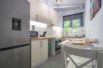 a white kitchen with white cabinets and a sink at Minimal Frame by ΜΡS in Athens