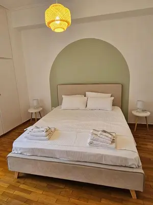 a bedroom with a large bed with an arch overhead at Athens City Center Apartments in Athens