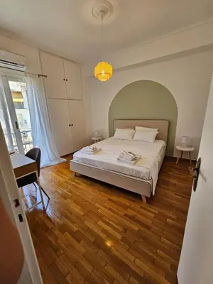 a bedroom with a bed and a table and a chair at Athens City Center Apartments in Athens