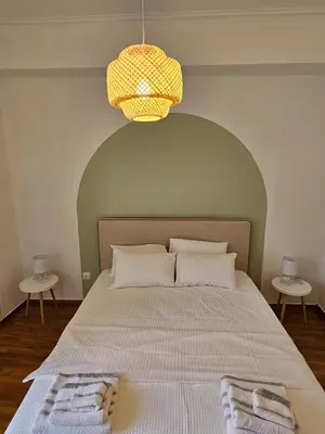 a bedroom with a large bed with a green headboard at Athens City Center Apartments in Athens