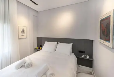 a bedroom with a large white bed with white pillows at Syntagma Acropolis M4 in Athens