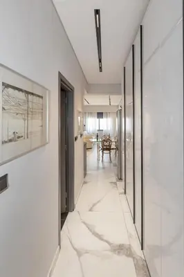 a hallway with white walls and marble floors and a hallway with glass doors at Syntagma Acropolis M4 in Athens