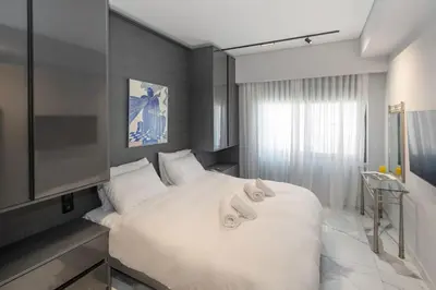 a bedroom with a large white bed with towels on it at Syntagma Acropolis M4 in Athens