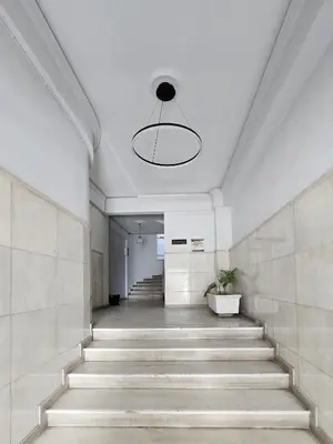 a hallway with stairs in a building with a light fixture at Syntagma Acropolis M5 in Athens