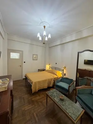 a bedroom with a bed and a couch and a table at Cozy vintage flat in Athens