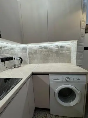 a white kitchen with a washing machine in it at Cozy vintage flat in Athens