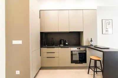 a kitchen with white cabinets and a counter with a stool at A43 Renovated in 2025 Great base for Koukaki in Athens