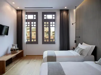 a hotel room with two beds and two windows at InnAthens in Athens