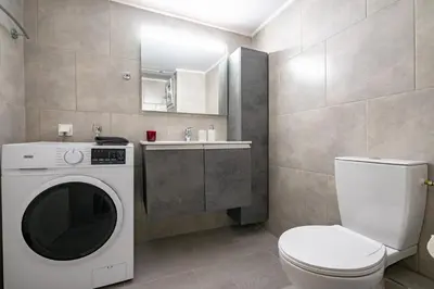 a bathroom with a washing machine and a toilet at Beba's House by ΜΡS in Athens
