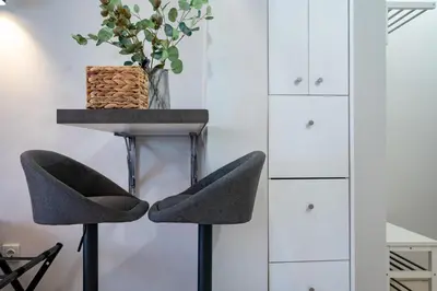 a table and two chairs in a room with white cabinets at Beba's House by ΜΡS in Athens