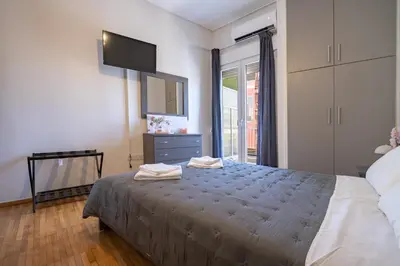 a bedroom with a bed with a tv and a window at Beba's House by ΜΡS in Athens