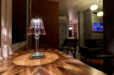 a lamp sitting on top of a wooden table at Luxury Penthouse 360 Acropolis and Athens Views in Athens