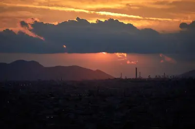 a view of a city with the sunset in the background at Luxury Penthouse 360 Acropolis and Athens Views in Athens