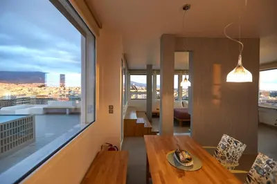 a living room with a table and a large window at Luxury Penthouse 360 Acropolis and Athens Views in Athens