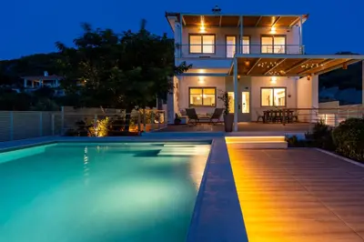 a house with a swimming pool at night at AK-Green Villa near Athens Airport in Vravrona