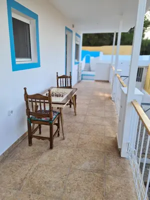 a patio with two chairs and a table on a house at Sea View House in Porto Rafti