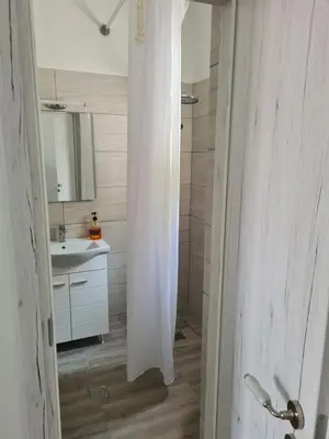 a white bathroom with a sink and a shower at Sea View House in Porto Rafti