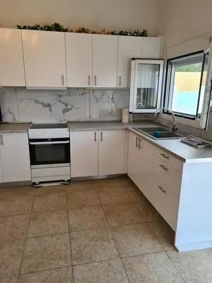 a kitchen with white cabinets and a sink at Sea View House in Porto Rafti