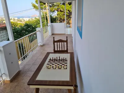 a chess board on a table on a balcony at Sea View House in Porto Rafti