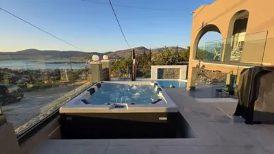 a hot tub on the balcony of a house at Helios Apartments Porto Rafti in Porto Rafti