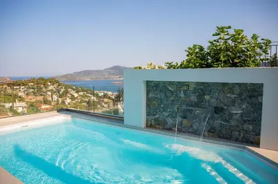 a swimming pool with a view of the ocean at Helios Apartments Porto Rafti in Porto Rafti