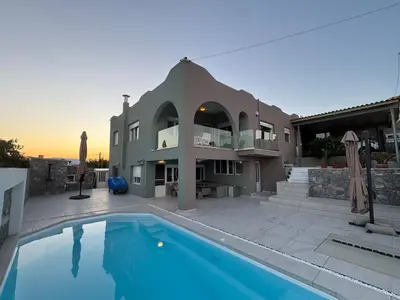 a house with a swimming pool in front of it at Helios Apartments Porto Rafti in Porto Rafti