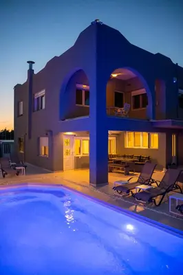 a house with a swimming pool in front of a house at Helios Apartments Porto Rafti in Porto Rafti
