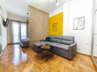 a living room with a couch and a table at Studio Σταθμός Λαρίσης 100Mbps , Μπαλκόνι in Athens